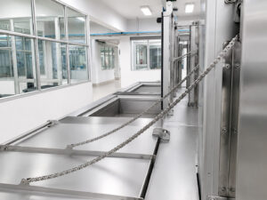 Automated door system on an ultrasonic washer featuring powered opening and closing operation for efficient loading, unloading, and containment of the cleaning process.