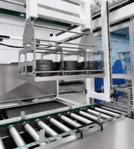 Automated handling system transferring parts between cleaning, rinsing, and drying stages of a multi-stage ultrasonic washer for fully automated processing.