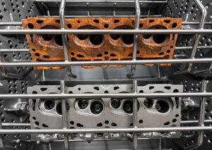 Side-by-side comparison of parts before and after processing through a fixed basket blaster, showing the removal of rust, scale, paint, and surface contaminants.