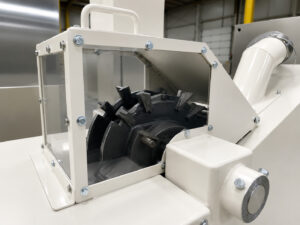 Close-up view of a brake deliner mechanism removing worn brake lining from a brake shoe, highlighting the tooling and separation process used during brake rebuilding.