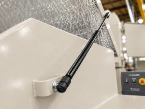 Heavy-duty door hinge on a vibratory tub finishing system designed to provide smooth lid operation and reliable support during loading, unloading, and maintenance.