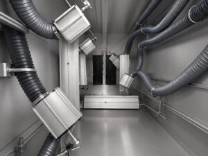 Interior view of the drying stage in a monorail flow-through washer featuring industrial air dryers and heated air circulation systems designed to remove moisture from cleaned parts.