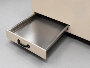 Dust collection tray partially pulled out from a downdraft table, showing the removable debris collection area used for capturing dust and particulate generated during operation.