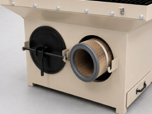 Filter partially removed from its service access location on a downdraft table, showing the filter housing and removable filter cap used for maintenance and replacement.