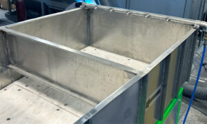 Loading ramp where wet parts and media enter a vibratory separator system before moving to a corn cob dryer.