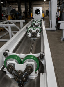 Exterior conveyor wheels on an interior pipe blaster used to support and transport pipes into and out of the blasting system.