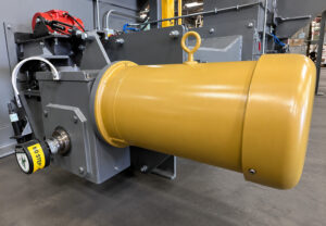 Heavy-duty impeller motor mounted on a slat blaster providing power to the blast wheel system for high-performance abrasive blasting of large industrial parts.