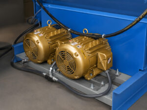 Heavy-duty impeller motors mounted on a fixed basket blaster providing power to the blast wheel system for abrasive cleaning and surface preparation operations.
