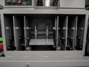 Interior view of a rebar blaster showing the blasting chamber, media flow components, and rebar transport path.