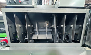 Interior view of a rebar blaster showing abrasive blasting components and the path of reinforcing steel through the system.