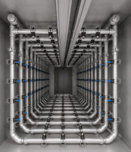 Interior view of a monorail flow-through washer featuring spray nozzles positioned throughout the wash chamber to deliver complete cleaning coverage to suspended parts.