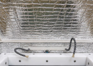 Insulated sidewall of a vibratory tub finishing system designed to reduce noise levels, improve operator comfort, and enhance overall workplace conditions.
