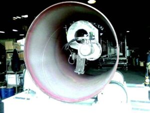 Interior view of a pipe during abrasive blasting, showing the inside surface being cleaned by an internal pipe blasting system.