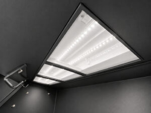 Interior light mounted inside an air blast cabinet providing clear visibility of parts during abrasive blasting operations.