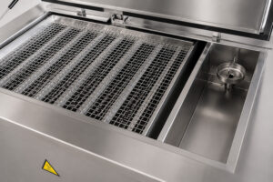 Lowering table on an ultrasonic washer designed to safely raise and lower parts into the ultrasonic cleaning tank for efficient immersion cleaning.