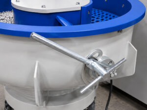Adjustment knob on the media separator of a vibratory bowl finishing system used to fine-tune the separation gap between finishing media and processed parts.