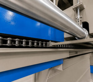 Close-up view of the monorail conveyor system inside an infrared cure oven, showing the overhead track used to transport parts through the curing process.