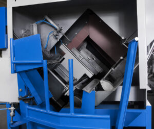 Optional angled loading system on a flow-through drum blaster designed to automatically guide steel drums into the blasting process.