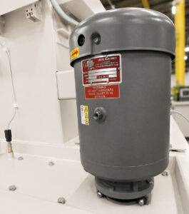 Industrial water pump on a small table washer circulating cleaning solution to the spray nozzles for consistent and effective part cleaning.