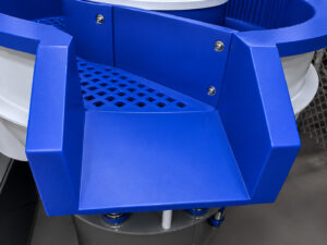Discharge ramp on a vibratory bowl finishing system guiding finished parts out of the machine after processing and media separation.