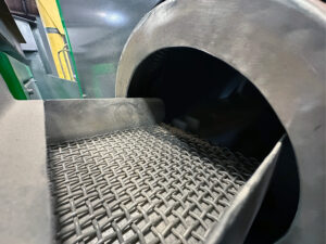 Vibratory separator ramp leading to a corn cob dryer used for separating media and drying parts after vibratory finishing.