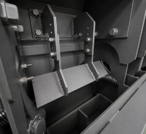Reflector panel inside a rebar blaster used to redirect abrasive shot toward reinforcing steel for improved blasting coverage.