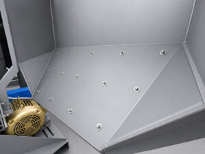 Replaceable wear liner inside a tumbler blaster designed to protect the blast chamber from abrasive wear and extend machine service life.