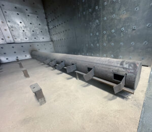 Slotted racks inside a walk-in burn-off oven used to support and space parts for efficient airflow and thermal cleaning.