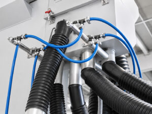 Tubing, piping, and connection points leading to the elevator system of a concrete and scaffold blaster used for abrasive media recovery and recirculation.