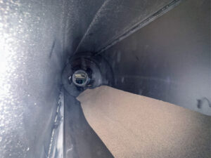 Interior view of a corn cob dryer showing drying media and processed parts inside the finishing system.