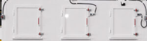 Side access panels on a chain mesh belt flow-through washer providing convenient entry for maintenance, inspection, cleaning, and servicing of internal components.