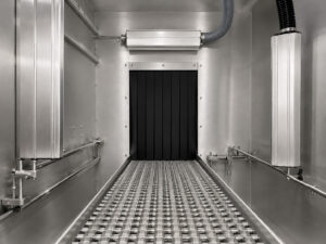 Interior view of the drying stage in a chain mesh belt flow-through washer, featuring heated air distribution and conveyor transport for efficient part drying.