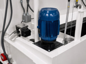 Close-up view of the impeller motor on a chain mesh belt flow-through washer, powering the pump system that circulates cleaning solution to the spray nozzles.