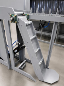 Angled view of an upender/downender automation and handling system designed to safely rotate parts between horizontal and vertical positions during production processes.