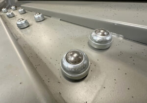 Close-up of rollers on an upender/downender used to support and rotate cylindrical parts during handling and positioning.