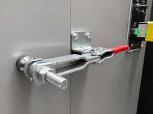 Heavy-duty door lock mechanism on a wheel rim blaster designed to securely seal the blast chamber during abrasive blasting operations.