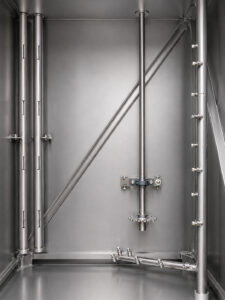 Interior view of a batch door-mounted table washer showing the rotating wash table, spray nozzle system, and wash chamber designed for complete cleaning coverage.