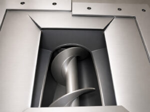 Auger system on a flow-through cylinder blaster used to collect and transport spent abrasive media for recycling within the blasting system.