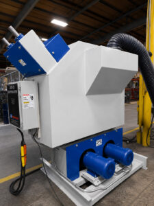 Rear angled view of a batch drum blaster highlighting the impeller motors that power the blast wheel system for abrasive blasting operations.