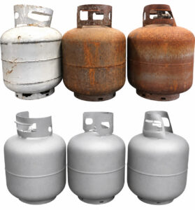 Side-by-side comparison of 20 lb propane tanks before and after processing through a flow-through cylinder blaster, showing the transformation from a worn surface to a clean, blast-prepared finish.