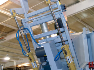 Cylinder lifted inside an interior cylinder blaster system during internal abrasive blasting and handling process.