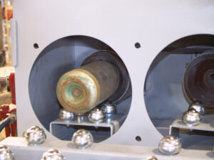 Interior view of a cylinder being blasted inside an internal cylinder blaster, showing abrasive cleaning of the inner surface.