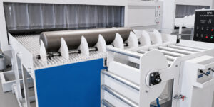 Freshly blasted cylinder at the exit of a flow-through cylinder blaster being held in place by an exit stopper to prevent uncontrolled movement.