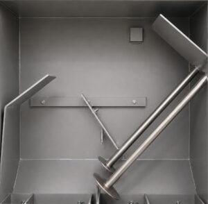 Interior view of a batch drum blaster showing the blasting chamber where steel drums are cleaned and surface prepared using high-velocity abrasive media.