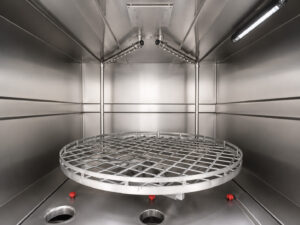 Alt Text: Interior view of a stainless steel washer showing the wash chamber, spray headers, nozzles, and cleaning area designed for efficient industrial part washing.