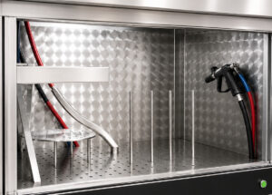 Inside view of the LS Industries Diesel Particulate Filter Washer (DPFX) showing the stainless-steel wash chamber, filter holding fixture, and high-pressure spray system designed to clean diesel particulate filters from multiple angles.