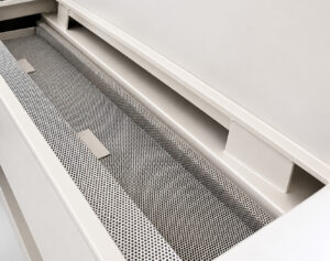 Oil skimmer mounted on a tumble washer designed to remove floating oils and contaminants from the cleaning solution to maintain wash performance and solution quality.
