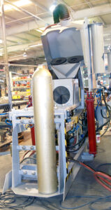 Upender/downender used with an interior cylinder blaster to tilt and position cylinders for internal abrasive blasting and handling.