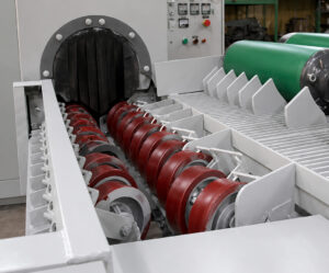 Conveyor wheels at the entrance of a flow-through cylinder blaster used to support, align, and transport cylinders into the blasting system.
