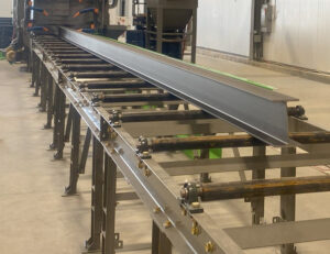Close-up view of industrial roller conveyors used for transporting parts and materials through automated production and handling systems.
